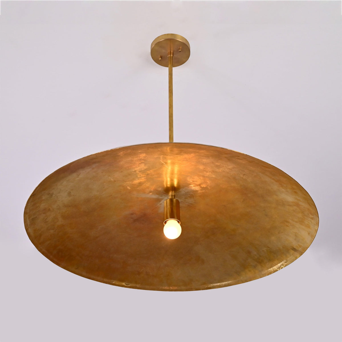 Close up of Aurelia Saucer Pendant Light showing broad saucer shade and warm central illumination.