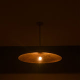 Aurelia Saucer Pendant Light glowing in a dark setting with soft downward ambient light effect.