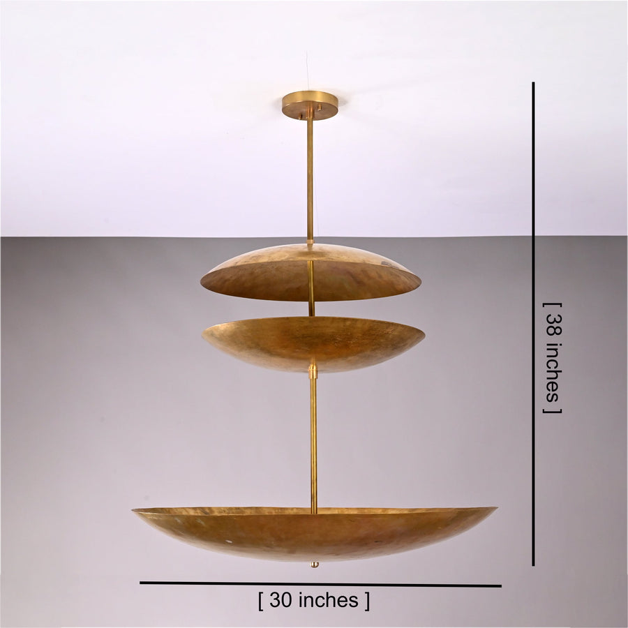 Aurora Triple Saucer Chandelier installed above a dining table in a warm modern interior.