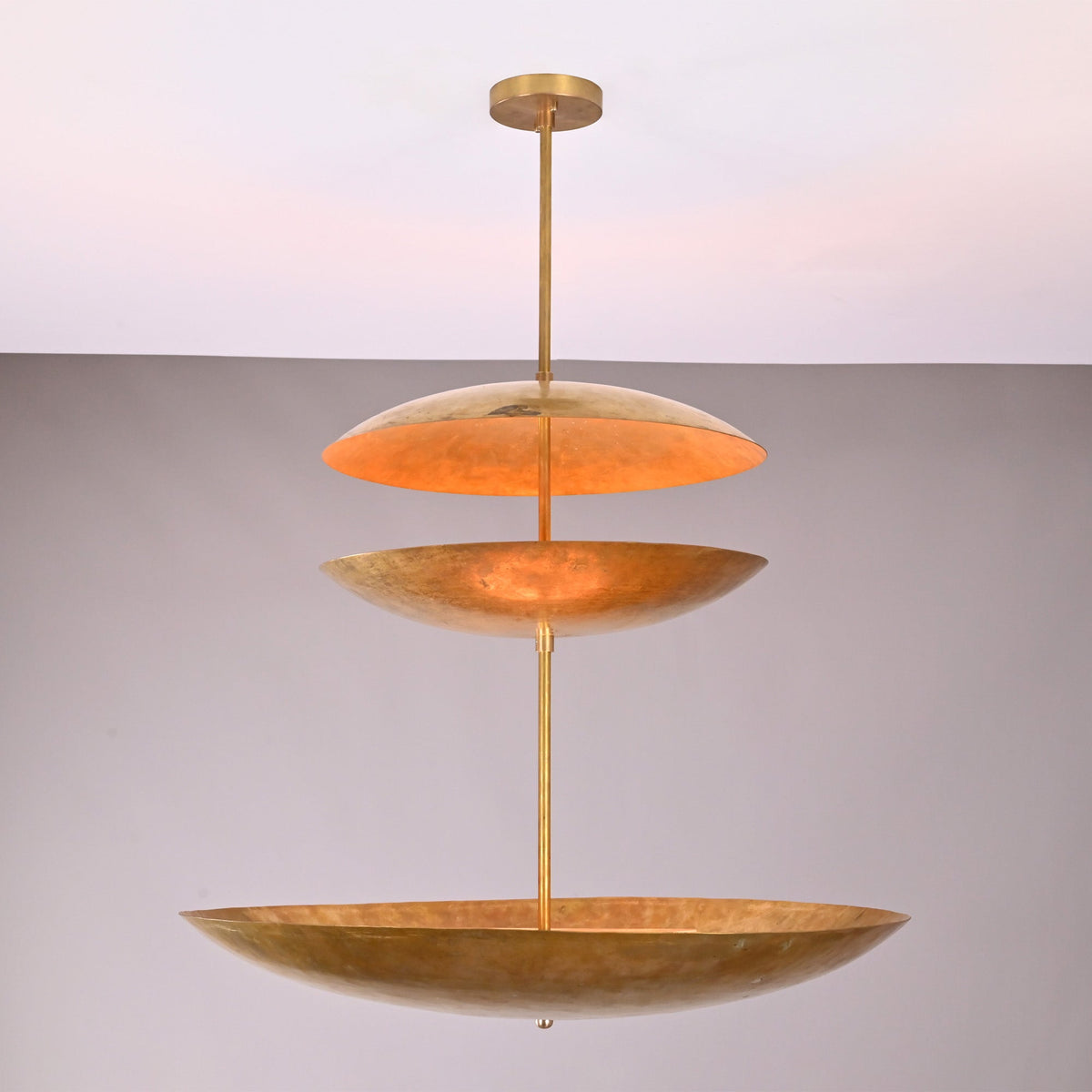 Front view of Aurora Triple Saucer Chandelier with three stacked saucer shades and warm layered glow.