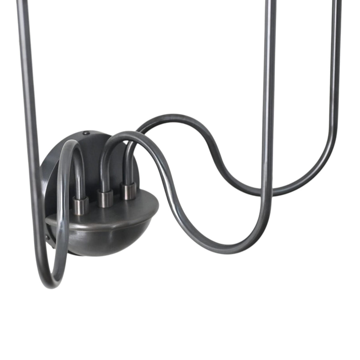 Close-up of the sconce’s rounded black metal base with three elegantly curved connecting arms showing refined craftsmanship and sturdy construction.