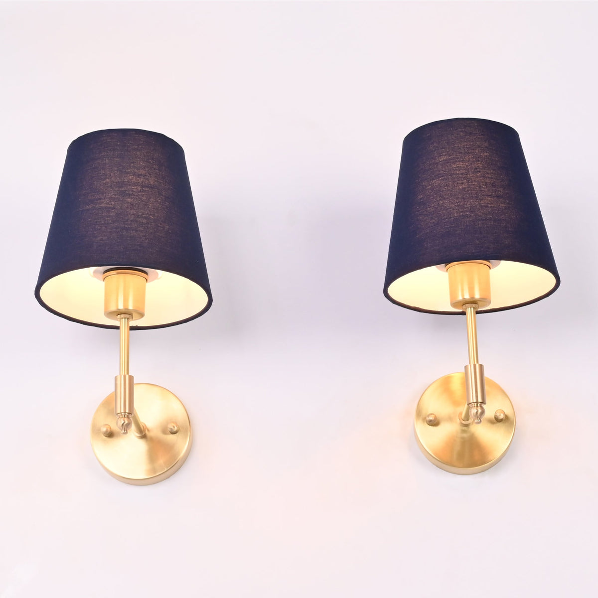 Bottom perspective of the antique brass wall sconce highlighting the rich blue fabric shade, brass socket, and warm downward light.