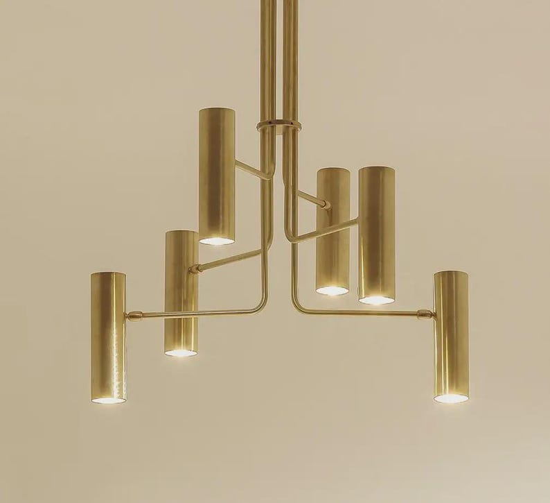Lower angle view of six-light brass chandelier showcasing balanced geometry and soft ambient glow.