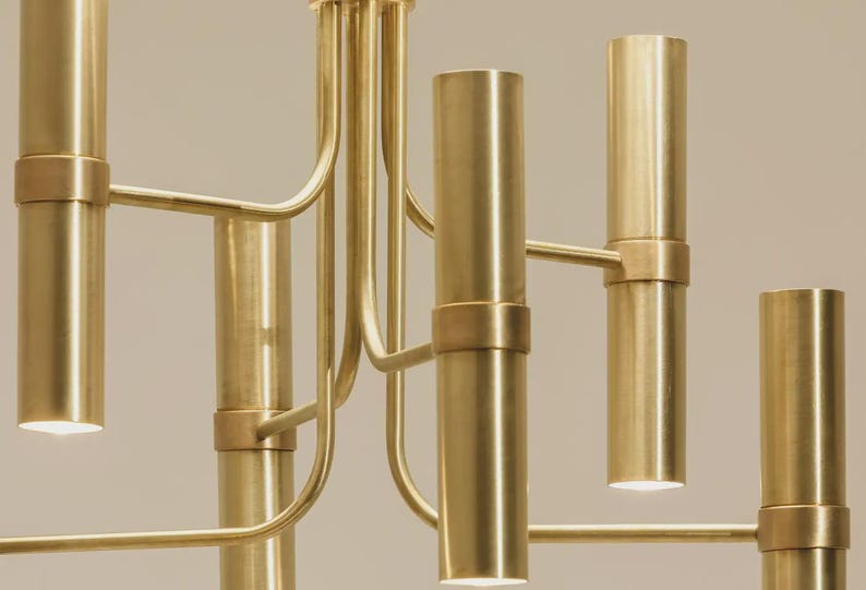 Close-up of cylindrical brass shades showing brushed finish and warm downward lighting