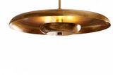 Close-up of brass disc chandelier underside showing bowl-shaped reflector and warm indirect ambient lighting.