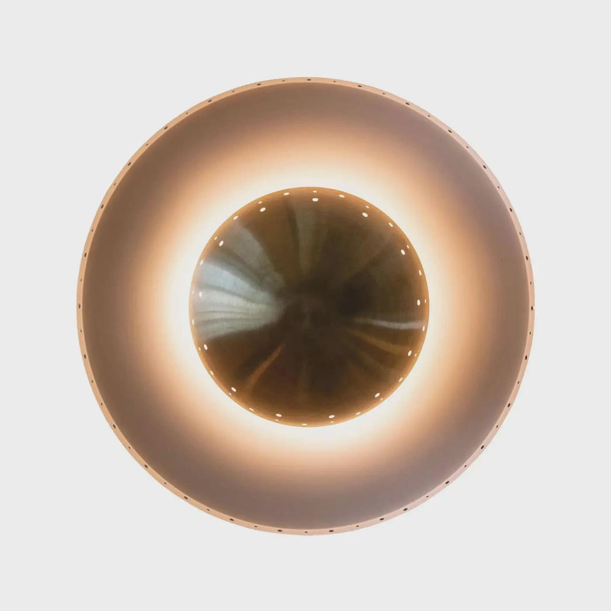 Close-up of brass bowl-shaped center shade with perforations, designed for soft indirect illumination.