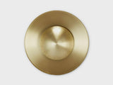 Top-down view of handcrafted brass disc flushmount ceiling light with circular sculpted form.