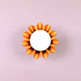 Handmade brass flower-shaped wall light with round bulb, viewed from the front, designed by Brass Leaf Studio.