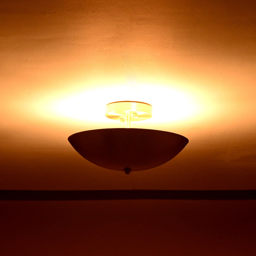 Elegant brushed brass bowl-shaped ceiling light emitting warm ambient glow from ceiling