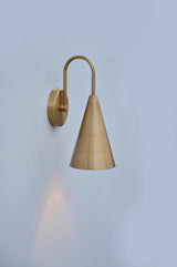 Minimalist brass wall light with cone shade and curved arm design, ideal for modern interiors and soft ambient glow.