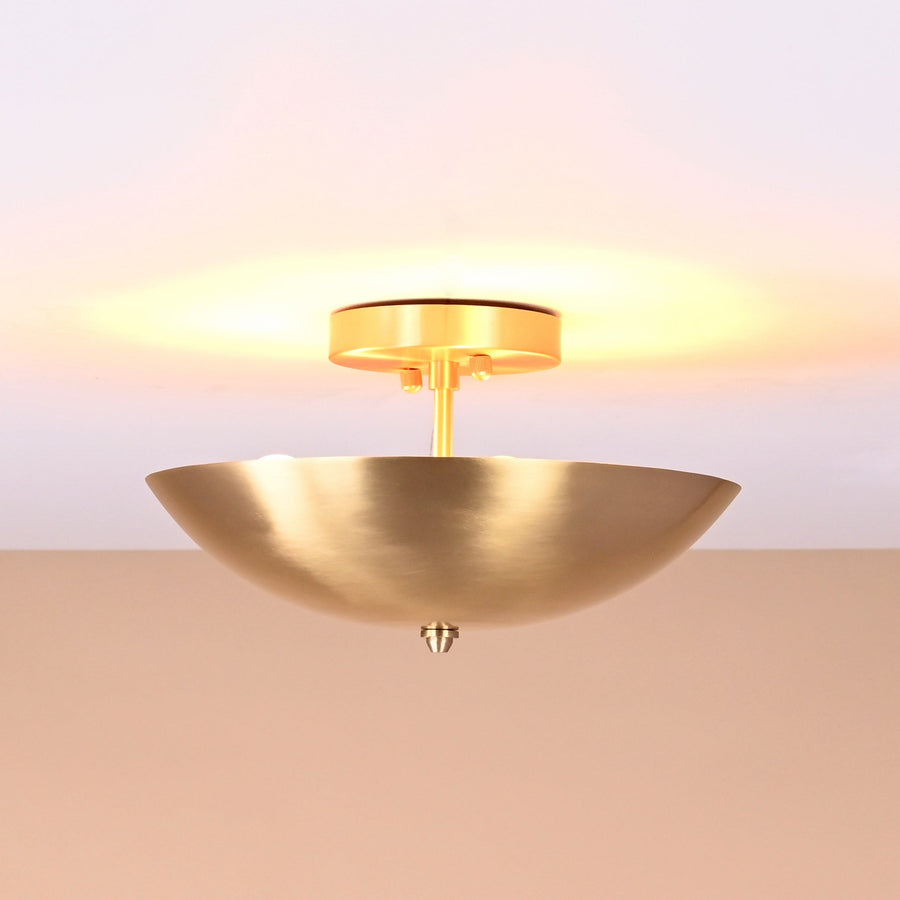 Elegant brushed brass bowl-shaped ceiling light emitting warm ambient glow from ceiling