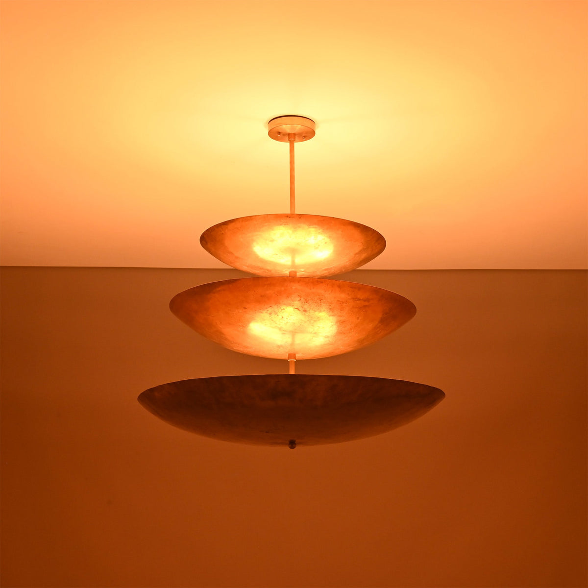 Close up of Celeste Triple Saucer Pendant Light highlighting warm light diffused through layered saucer shades.