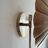 Close-up of round brass wall canopy and E26 socket holder with adjustable joint in brushed brass finish.