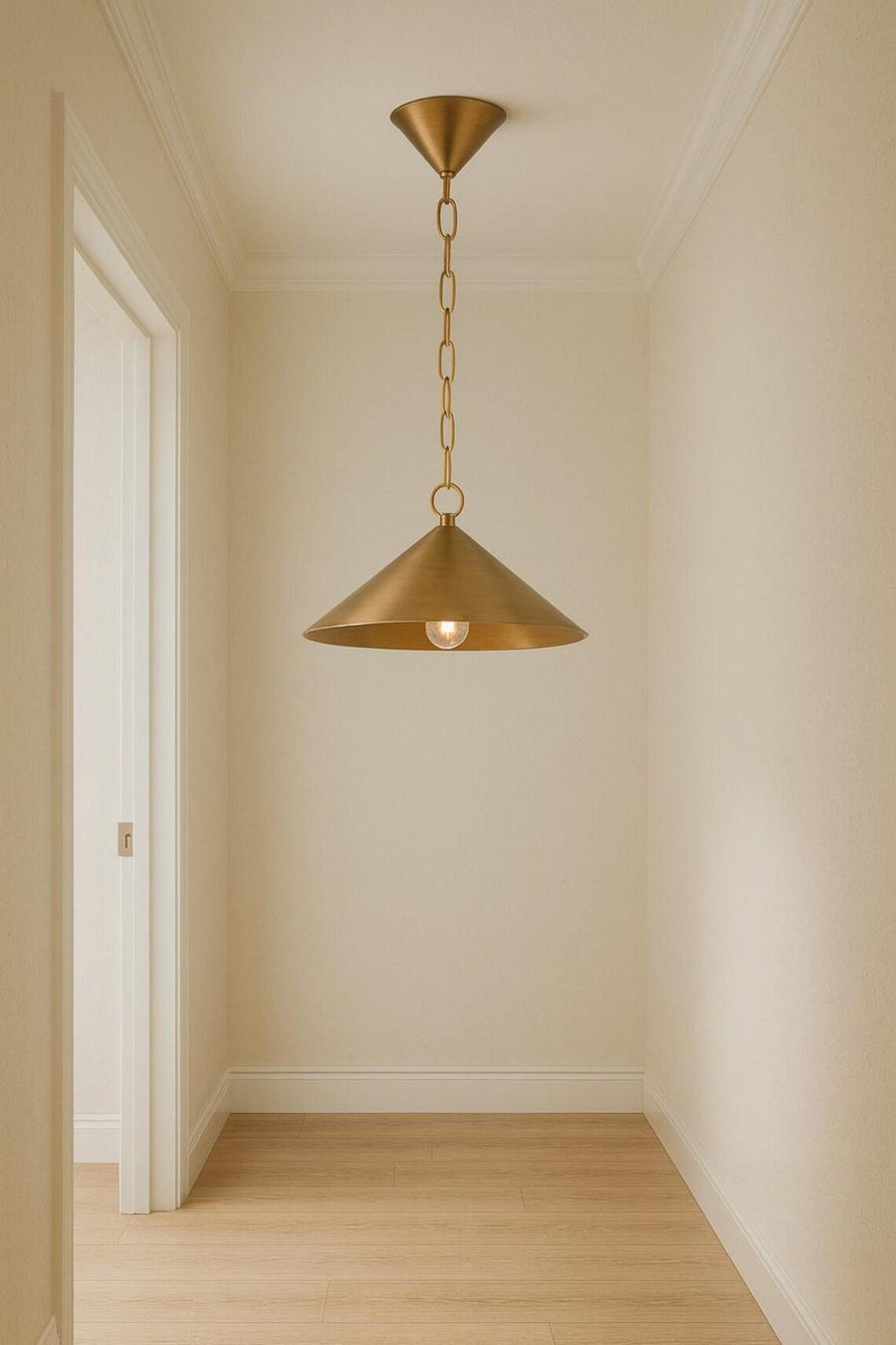 Brushed brass cone pendant chandelier with chain hanging in a narrow hallway with light wood flooring.