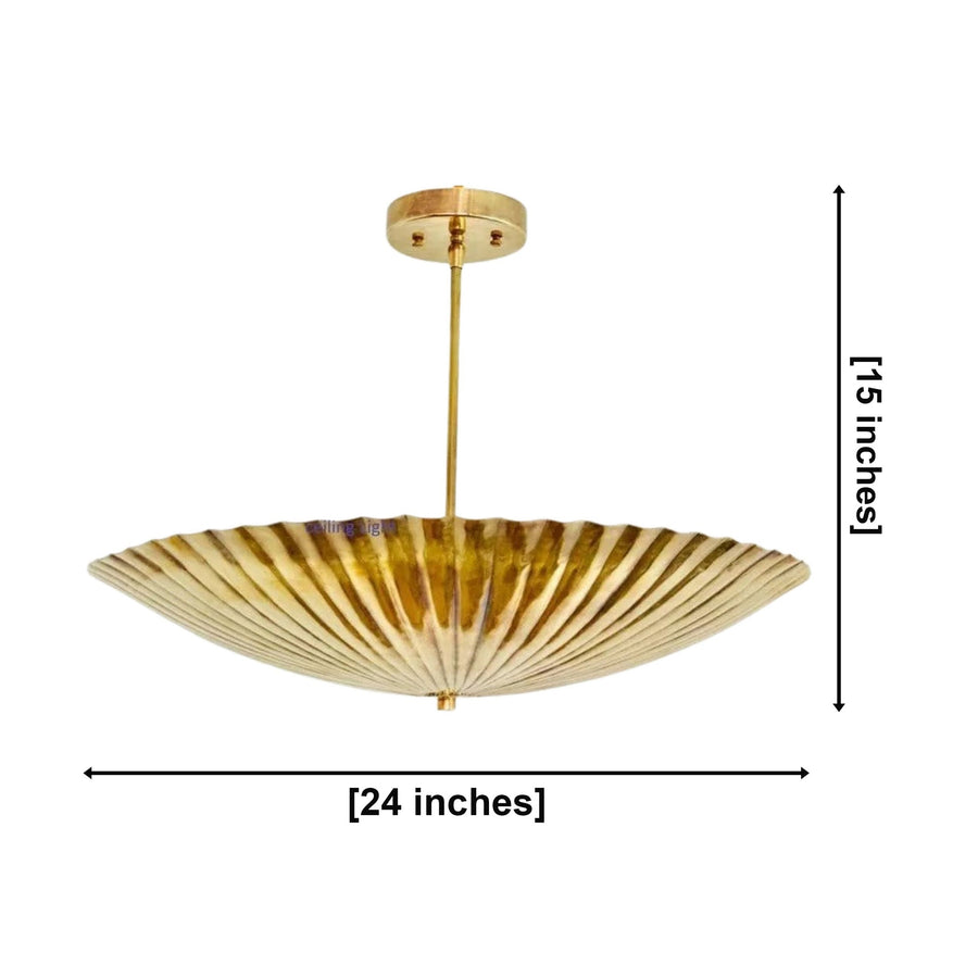 Crete 5 light brass fluted bowl chandelier illuminated above a round dining table in an elegant warm modern dining room.
