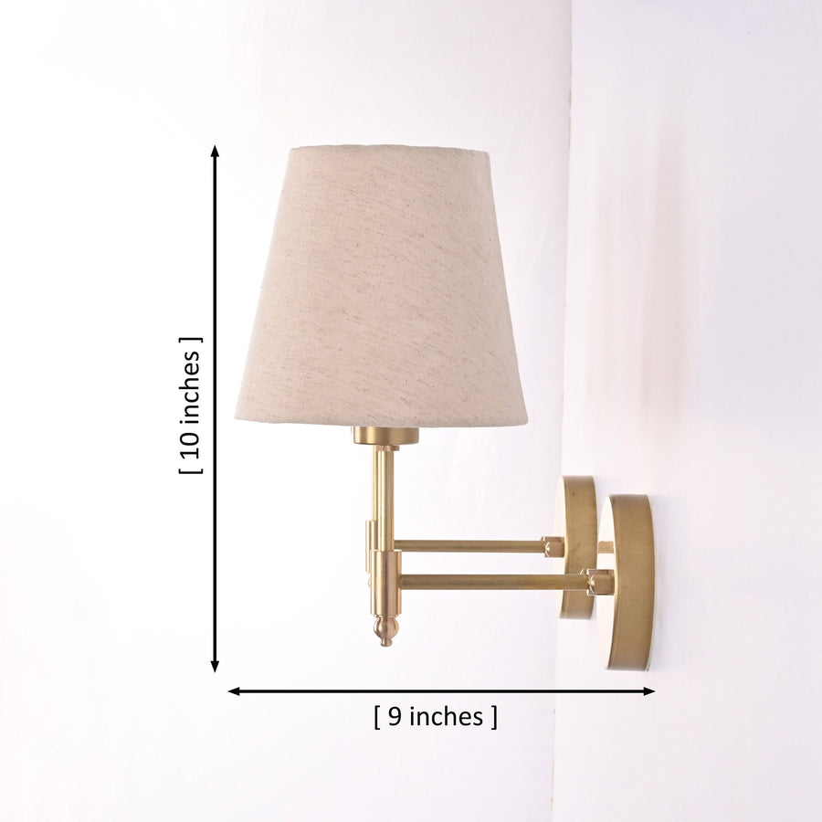 Milan natural linen shade brushed brass wall sconces installed beside framed artwork in an elegant dining room with warm ambient lighting.