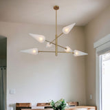 Frosted glass cone brass chandelier elegantly suspended above a dining table, casting soft ambient light in a modern home interior.