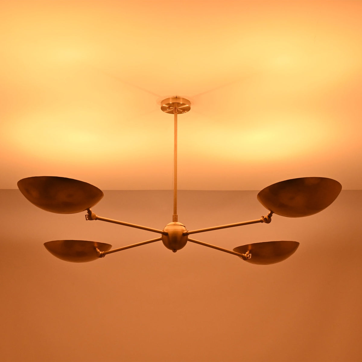 Ambient lighting view of the Hudson Modern Quad Bowl Chandelier creating soft upward illumination with adjustable bowl shades.
