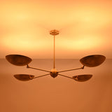 Ambient lighting view of the Hudson Modern Quad Bowl Chandelier creating soft upward illumination with adjustable bowl shades.