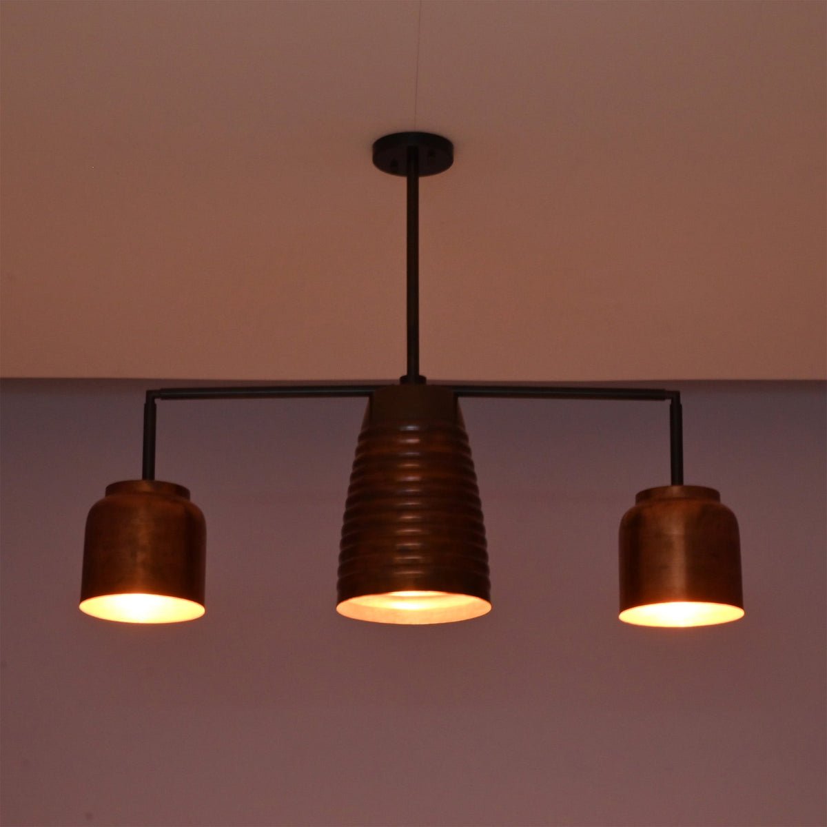 Front night view of the Hudson Modern Linear Three Shade Chandelier showcasing balanced warm lighting and a sculptural linear silhouette.