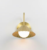 Profile view of brushed brass wall mounted sconce with fluted shade and round backplate