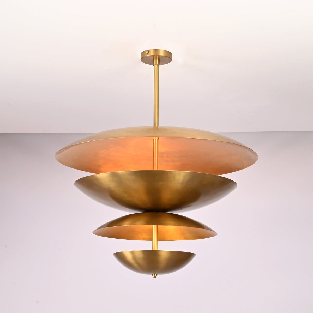 Illuminated front view of the Lior Modern Tiered Disc Chandelier showcasing soft glare-free light through layered metal discs