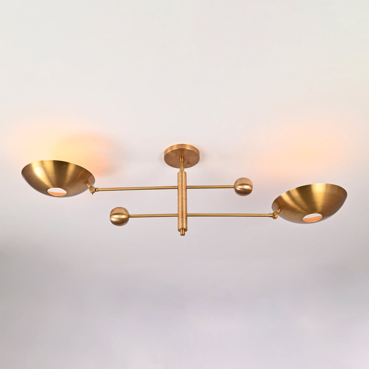 Perspective view of the Luna Modern Double Bowl Chandelier featuring asymmetrical bowl shades and Mid-Century Modern brass design