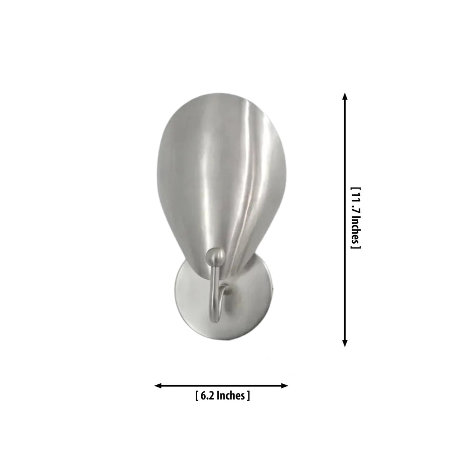 The Luna Sculptural Petal Wall Sconce installed beside a modern bedroom, providing warm ambient lighting with its sculptural satin nickel petal shade in a contemporary interior.