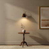 Marlow wall sconce featuring a dark bell-shaped metal shade, curved brass arm and round wall canopy – Model 32809