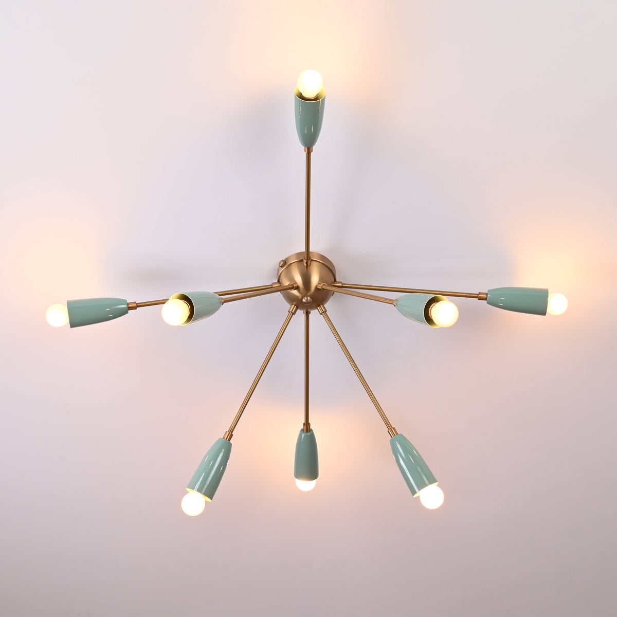 8-light starburst mint cone ceiling fixture in brass – illuminated top view
