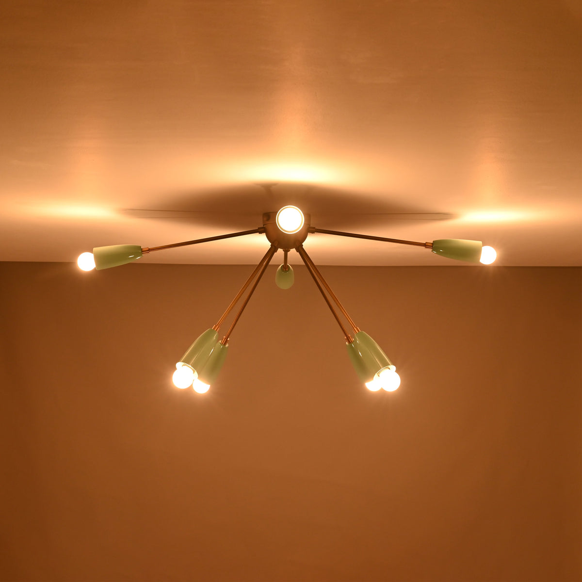 8-light brass and mint enamel flush mount chandelier glowing from ceiling