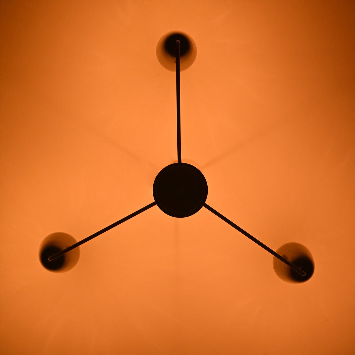 Bottom view of Milan Cone Arm Chandelier showing three arm layout and warm ceiling light effect.