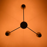 Bottom view of Milan Cone Arm Chandelier showing three arm layout and warm ceiling light effect.