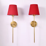 Pair of Milan red shade rod wall sconces with round wall plates and elegant long stem design.