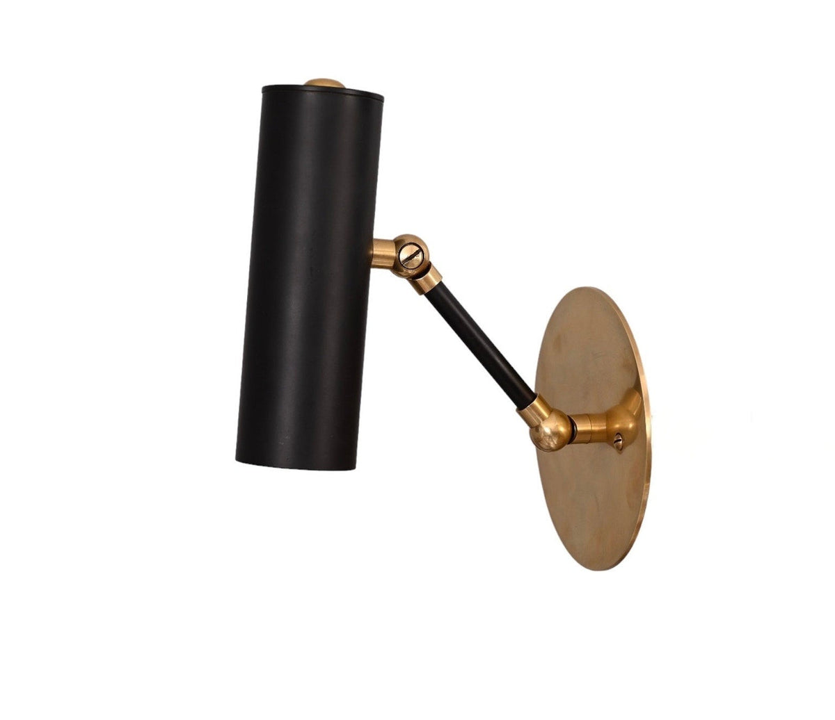 Close angled view of modern brass and black adjustable wall spotlight with cylindrical shade