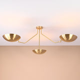 Elegant brushed brass three-arm flushmount ceiling light casting soft ambient glow, handcrafted by Brass Leaf Studio