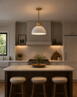 Naxos 1 light white dome pendant with brass-tone accents displayed above a modern kitchen island with warm ambient lighting.