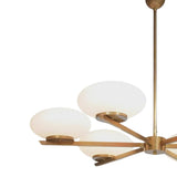 Angled close-up of Orion chandelier showing opal glass shades, brass fittings and sculptural arm design.