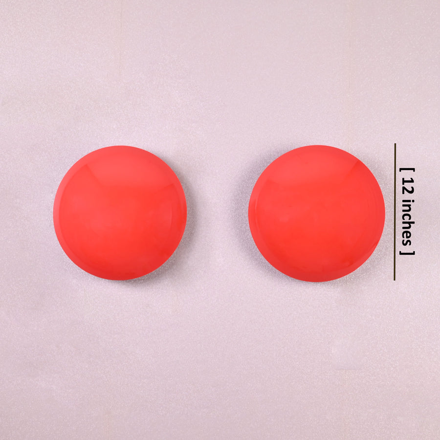 Set of two red disc wall sconces glowing with warm ambient halo, modern eclipse-inspired brass wall lighting