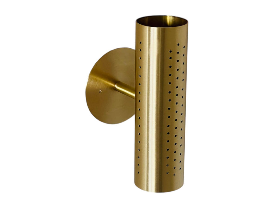 Front view of perforated brass cylinder wall sconce with round backplate on a gray background.