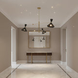 Portofino 3 light sculptural chandelier with brass linear arms, black perforated cone shades, and warm illuminated bulbs.