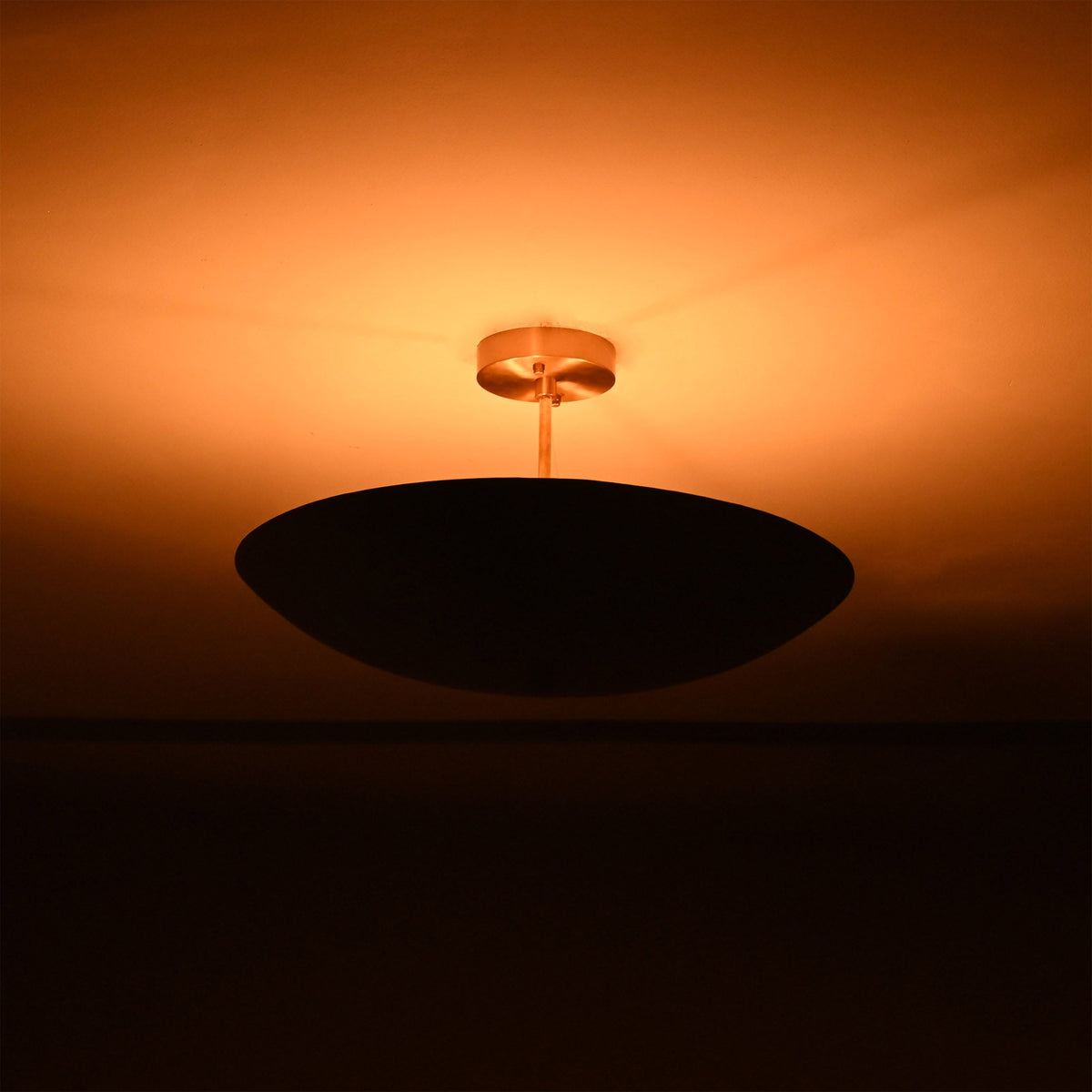 Side view of Rome Disc semi-flush ceiling light creating soft warm ambiance with a low-profile disc design.