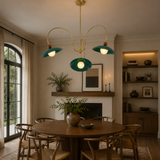 Rouen 3 light teal dome chandelier installed above a round dining table in a warm Mid-Century Modern dining room.