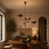Seoul 3 light sculptural counterbalance chandelier displayed above a wooden dining table in a warm Mid-Century Modern dining room.