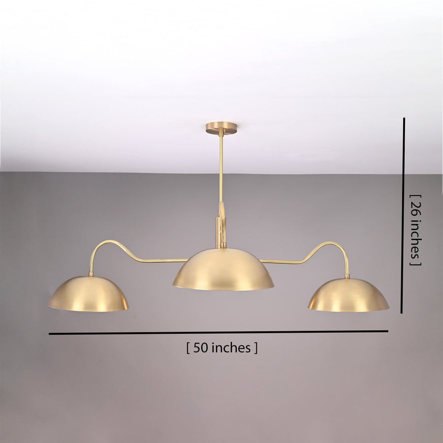 Siena Curved Arm chandelier glowing above a dining table in a cozy kitchen with warm ambient lighting.