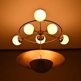 Siena Globe Disc Chandelier illuminated with six round globes, warm ambient glow, and bold lower disc detail.