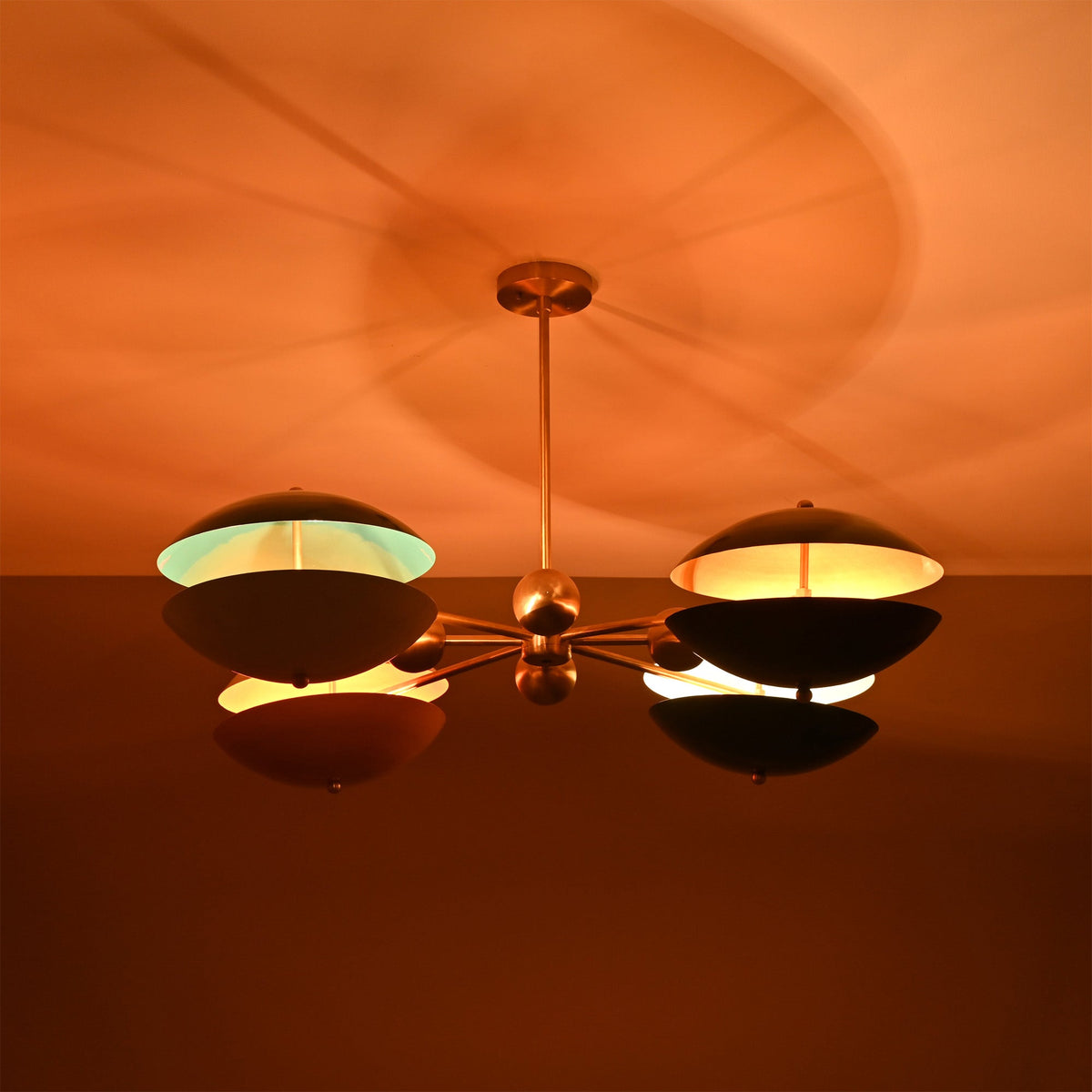 Siena Orbit Globe Chandelier ceiling view showing glowing color-blocked shades and soft shadow pattern.