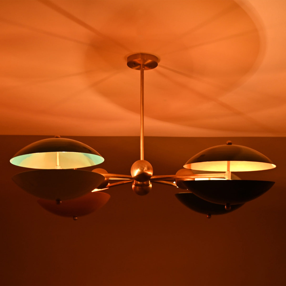 Siena Orbit Globe Chandelier close ceiling view with warm ambient glow and sculptural orbit frame.