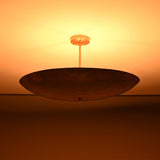 Siena Single Disc Chandelier close-up with glowing ceiling effect and dramatic low-profile bowl silhouette.