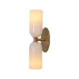 Front illuminated view of the Sloane Double Cylinder Alabaster Wall Sconce in solid brass featuring handcrafted natural alabaster cylinder shades.